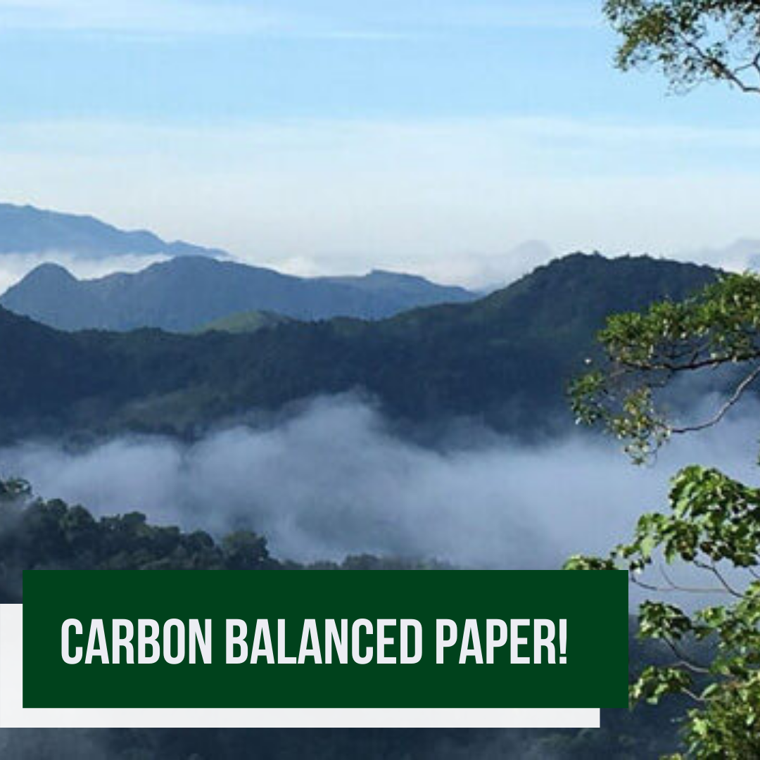 Lush green mountains with mist, promoting carbon balanced paper.