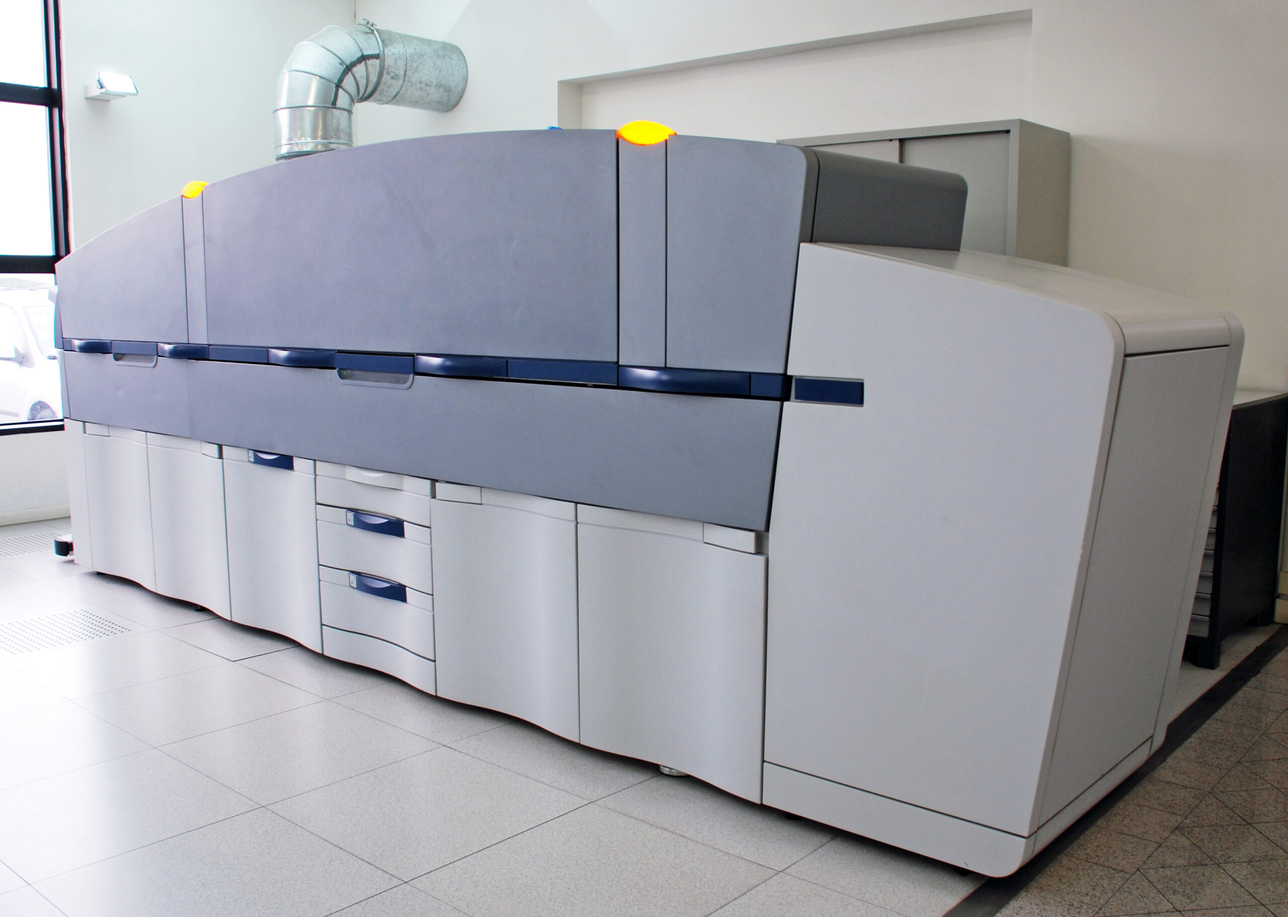 Large digital printing machine in a brightly lit room.