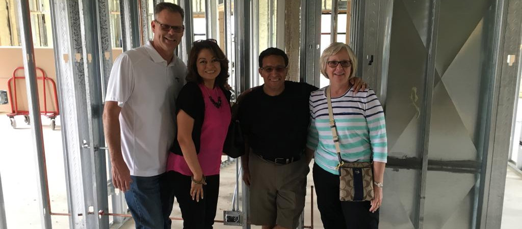 Group of four at new office construction site, July 2016