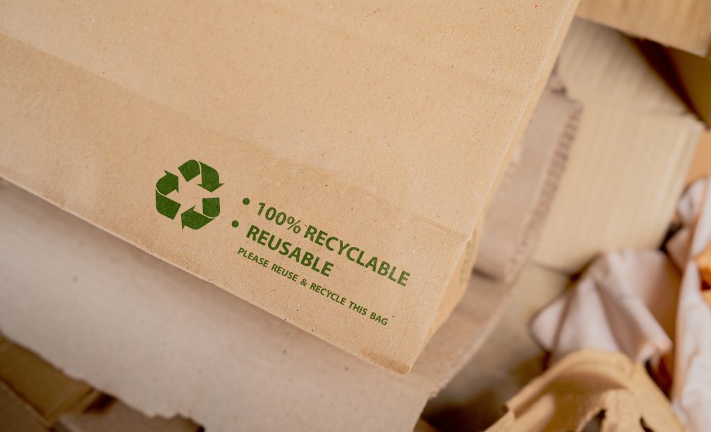Brown paper bag that is 100% recyclable and reusable with green recycling symbol. eco-friendly and save the world concept